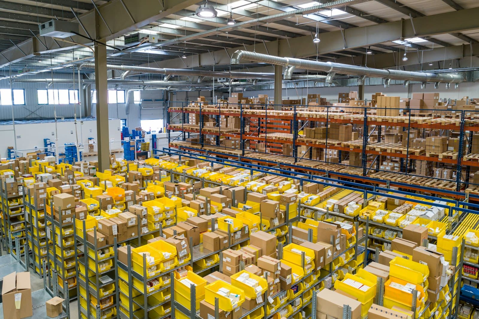 A warehouse aisle with pallet racking and goods in motion